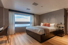 Beautifully appointed guest cabin on Cada Dia with soft neutral finishes, wood flooring, and large windows bringing natural light and ocean views inside.