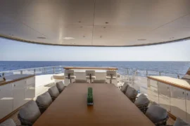 Alfresco dining deck on Cada Dia with a large dining table, panoramic ocean views, and an open-air layout designed for relaxed luxury entertaining.