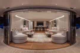 Seamless indoor-outdoor living aboard Cada Dia with a wide-open salon, curved architecture, and elegant entertaining space framed by sea views.